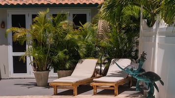 Una piscina con sillas de descanso y una escultura decorativa.
