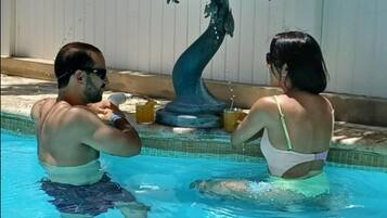 Una piscina al aire libre, sillones reclinables de piscina