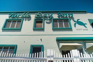 Un edificio con el letrero "Turtle Bay Inn" y un logo de tortuga.