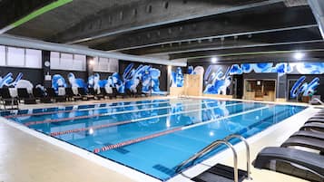 Una piscina techada, sillones reclinables de piscina