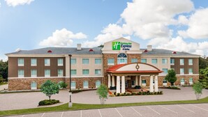 A Holiday Inn Express building with a brick facade, a covered entrance, and a parking lot.
