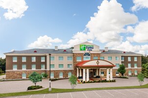 A Holiday Inn Express building with a brick facade, a covered entrance, and a parking lot.