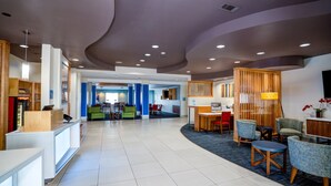 A spacious lobby with a reception desk, seating area, and a view of the dining area.