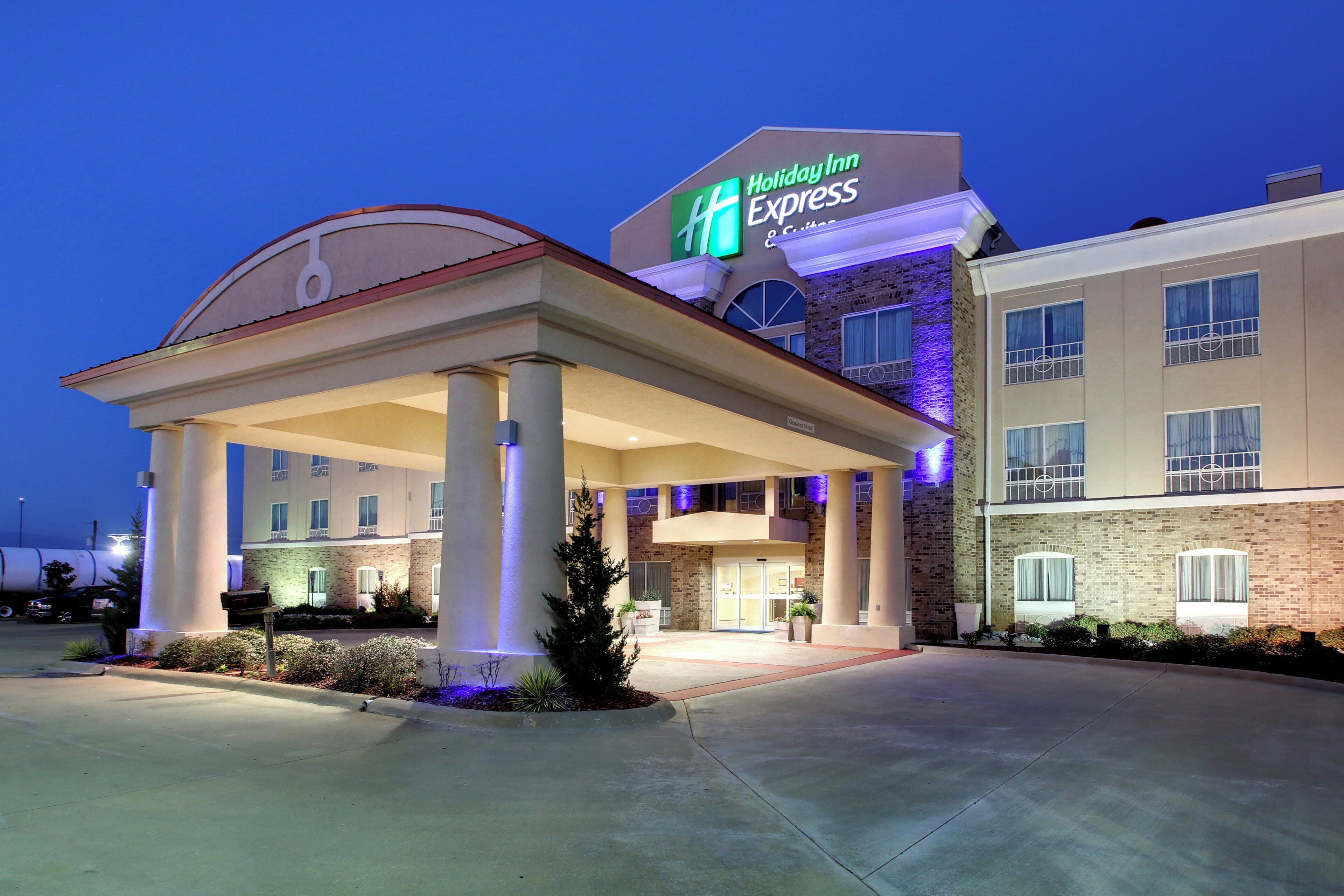 A Holiday Inn Express hotel with a covered entrance, a brick facade, and a clear sky.