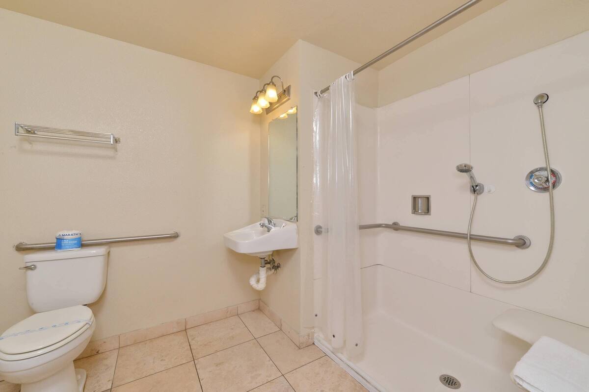 A bathroom with a toilet, sink, and shower.