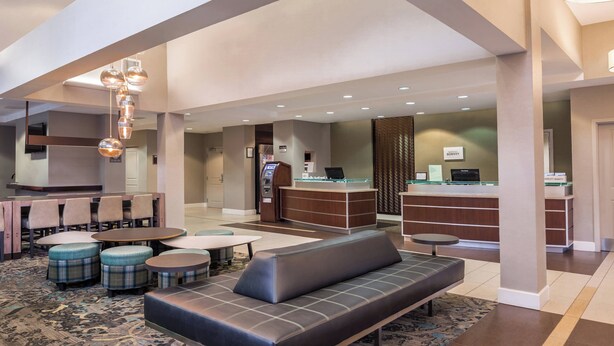 A hotel lobby with a seating area, a reception desk, and a check-in counter. - Residence Inn Florence Marriott (Florence)