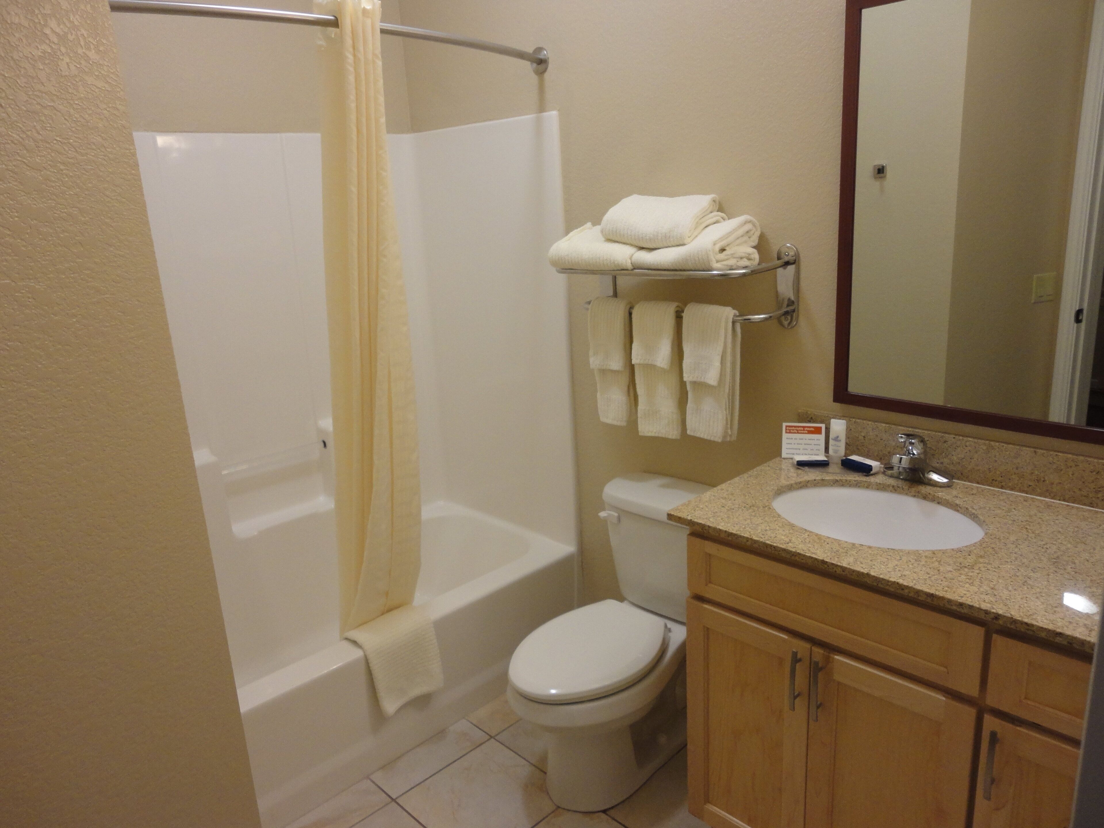 Une salle de bain avec une baignoire, des toilettes, un lavabo et un miroir.