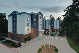 Un hotel de varios pisos con un diseño moderno, que presenta fachada de ladrillo y una paleta de colores azul y blanco.