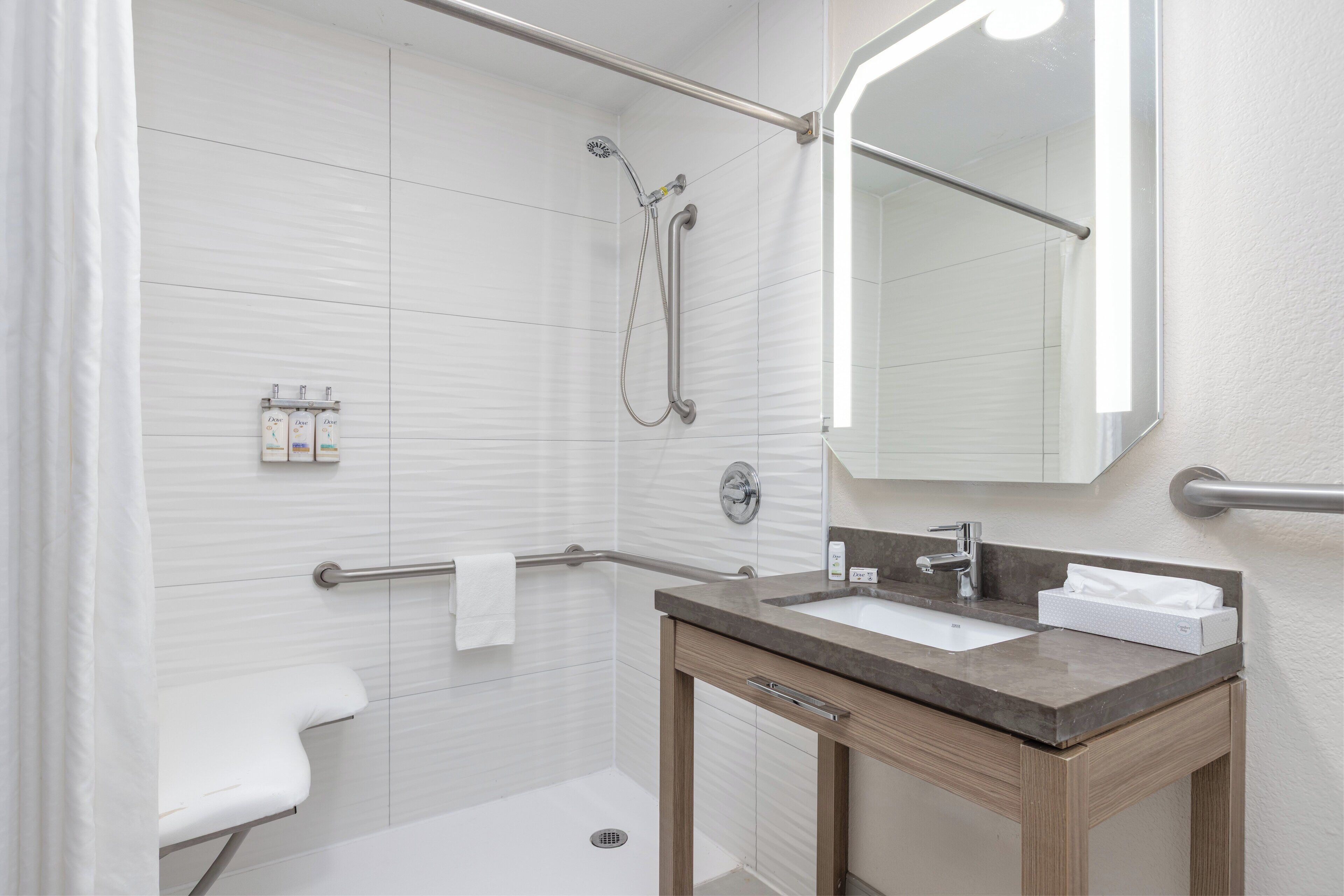 A modern bathroom with a shower, toilet, and sink.