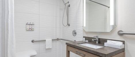 A modern bathroom with a shower, toilet, and sink.