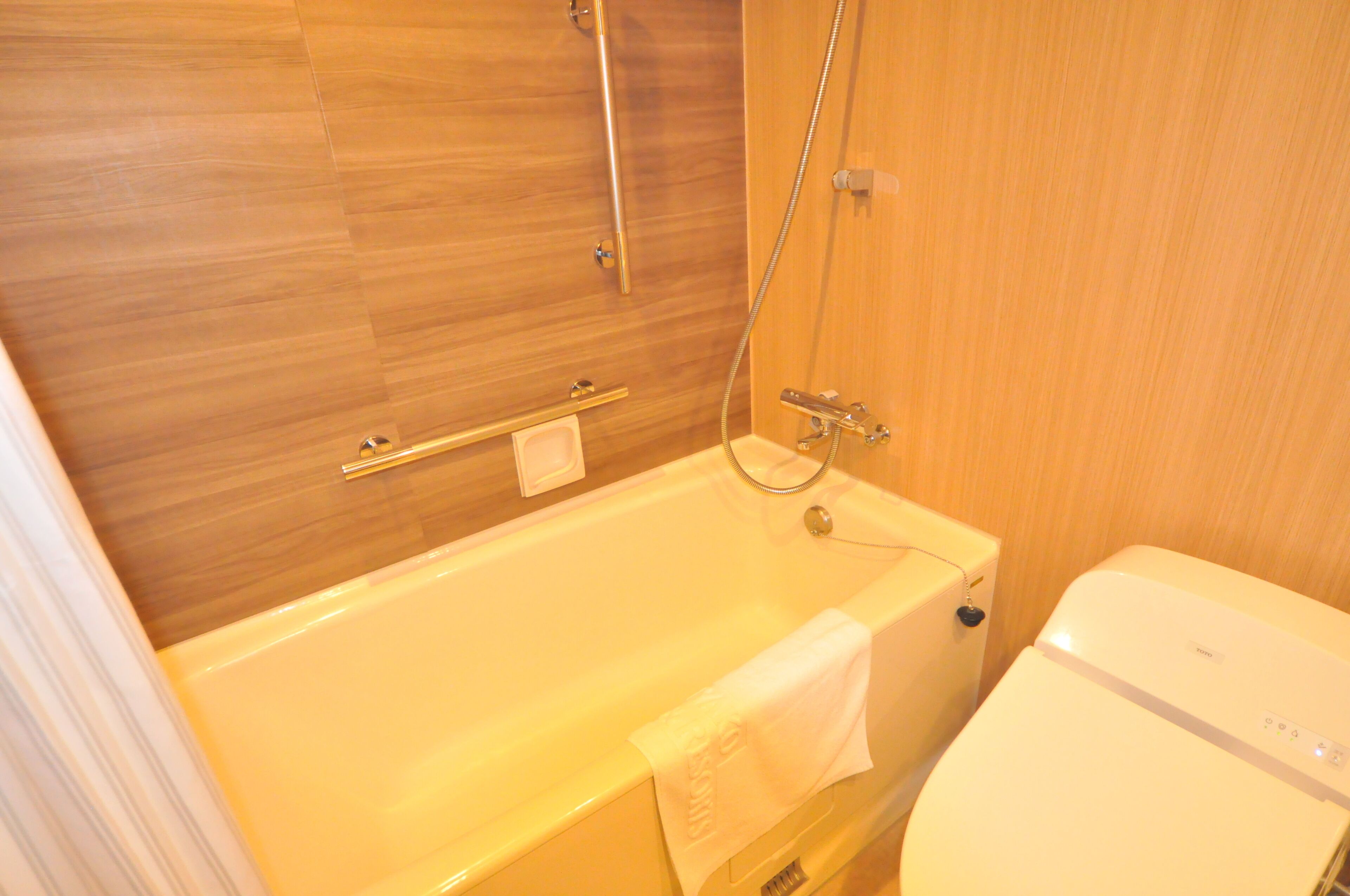 A bathroom with a bathtub, a toilet, and a shower area.