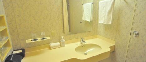 A bathroom with a sink, mirror, and towel rack.