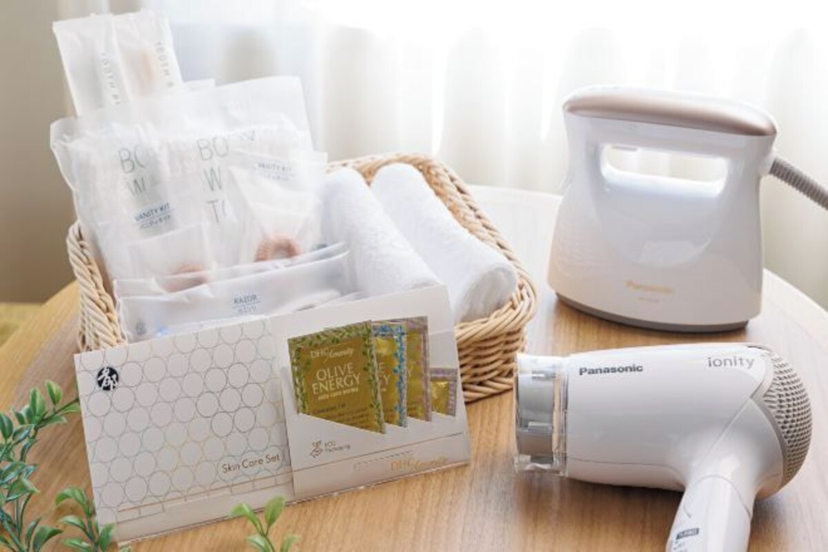 Un secador de pelo Panasonic ionity, una cesta con productos para el cuidado de la piel y una caja de sérum cosmético.