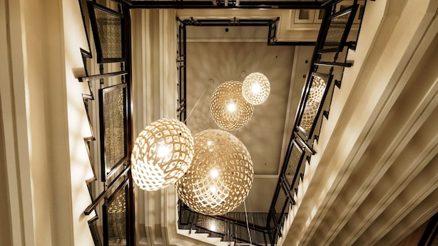 A modern staircase with geometric patterns and hanging spherical lights. - INFINISIS NAHA SHURIJO by Hewitt Resort (Naha)