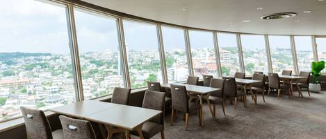 A modern dining area with large windows offering a city view.