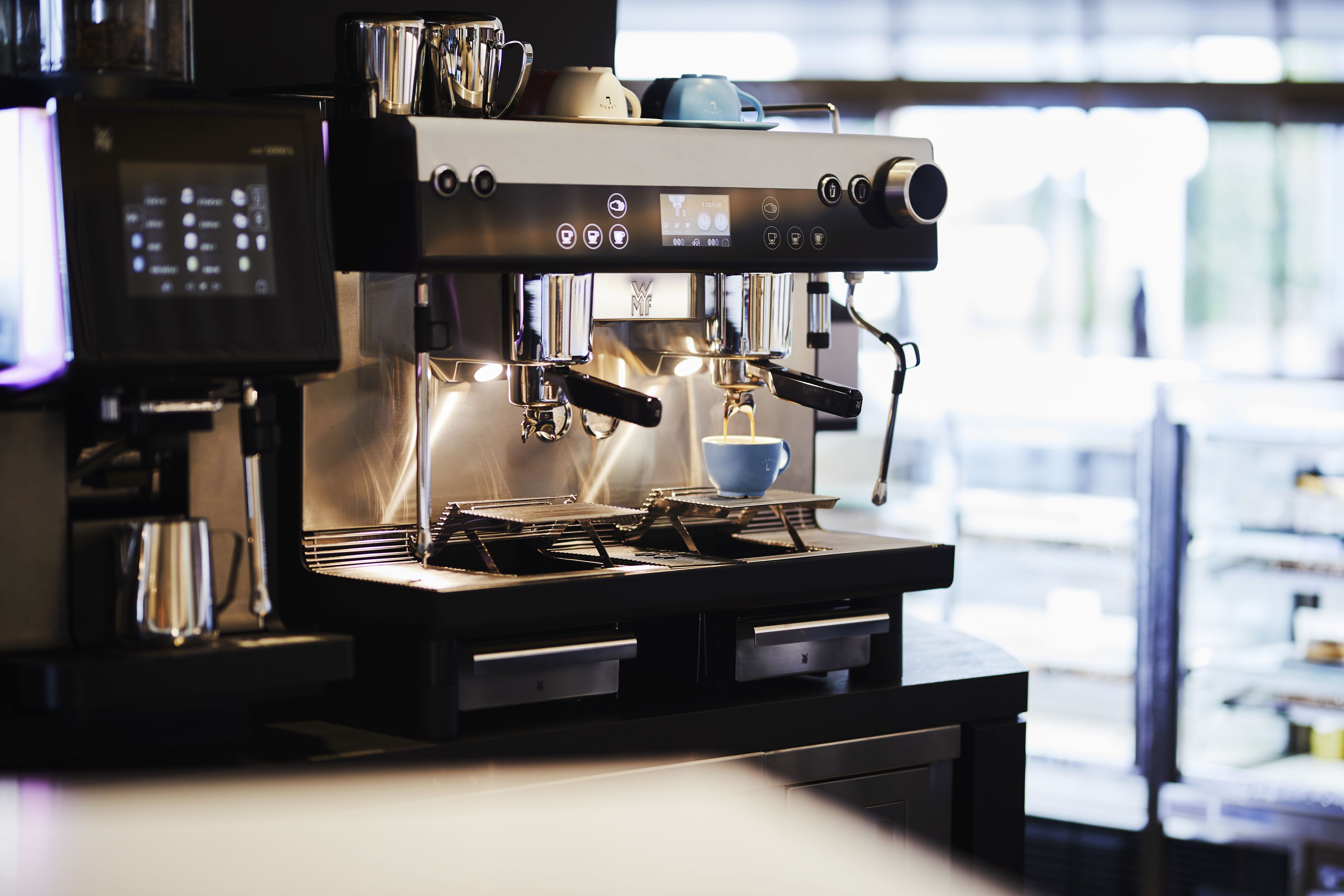 A coffee machine with a digital display and multiple coffee dispensers.