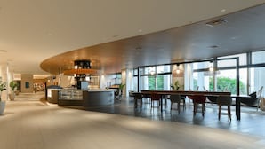 A spacious lobby with a reception desk, seating area, and large windows offering views of the outdoors. - INFINISIS NAHA SHURIJO by Hewitt Resort (Naha)