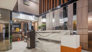 A reception area with a marble counter, wooden paneling, and a digital information kiosk. - Guide Hotel Taipei Fuxing N (Taipei)