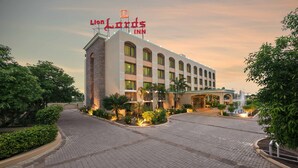 Un hotel con un letrero llamativo que dice "Lion's Inn" y un área exterior bien cuidada con senderos pavimentados y jardines.