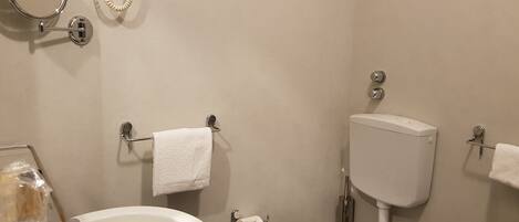 Un baño con inodoro, lavabo y espejo.