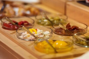 A buffet with various dishes in clear bowls, including some with visible ingredients like meat and vegetables.