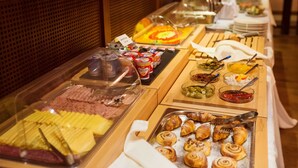 Ein Buffet mit verschiedenen Speisen, darunter Fleisch, Gebäck und Desserts.