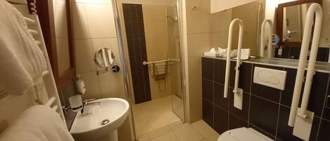 A bathroom with a sink, toilet, and shower.