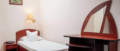 Habitación de hotel con cama, mesita de noche, lámpara y un espejo grande.