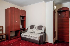 A compact room with a sofa, a wooden wardrobe, and a small table. - Egreta (Tulcea)