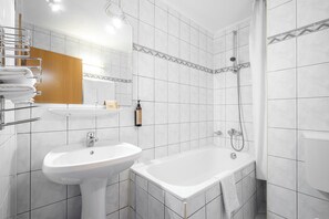 Un baño moderno con un lavabo blanco, una bañera y una ducha.