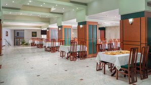A spacious dining area with multiple tables and chairs, a tiled floor, and a high ceiling with recessed lighting. - Egreta (Tulcea)