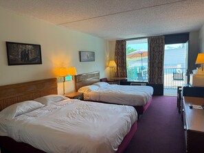 Ein Hotelzimmer mit zwei Betten, einem Schreibtisch, einem Sessel, einer Lampe und einem Fenster mit Vorhängen.