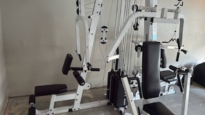 A gym with various exercise equipment, including a bench press, leg press, and cable machine. - Ozark Valley Lodge (Branson)