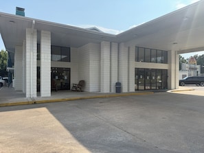 A building with a tiled facade, large windows, and a covered entrance area with outdoor seating. - Ozark Valley Lodge (Branson)