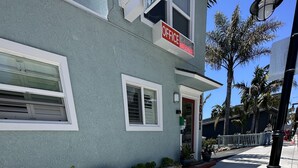 A building with a sign reading "OFFICE" and a welcome mat outside. - The Palomar Inn (Pismo Beach)