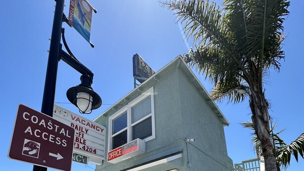 A two-story building with a sign indicating 'Office' and 'Coastal Access'. - The Palomar Inn (Pismo Beach)