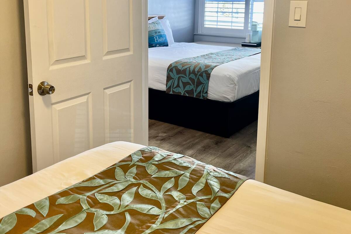 A bedroom with a bed, a window, and a door.