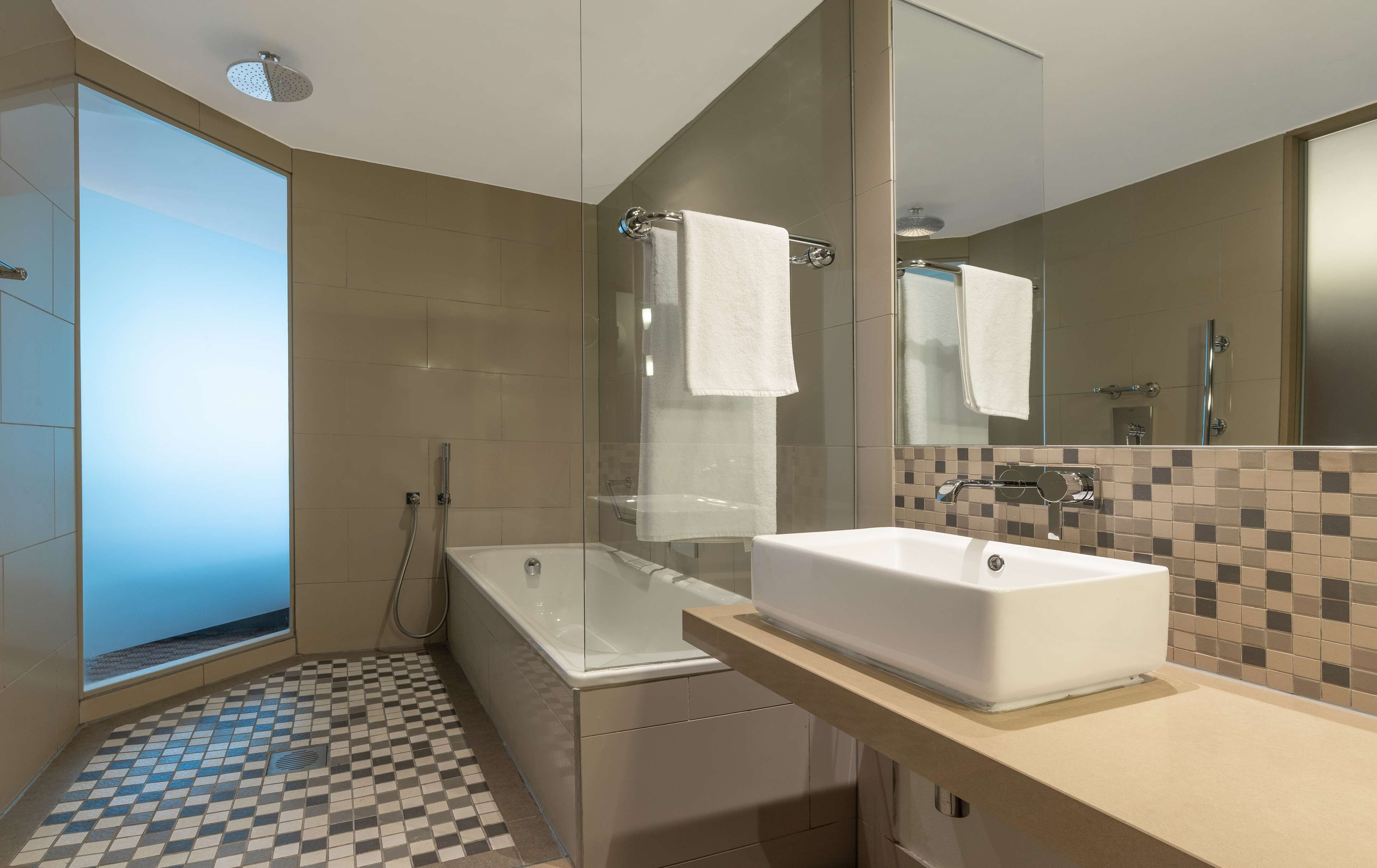 separate bathtub and shower, rainfall showerhead, designer toiletries