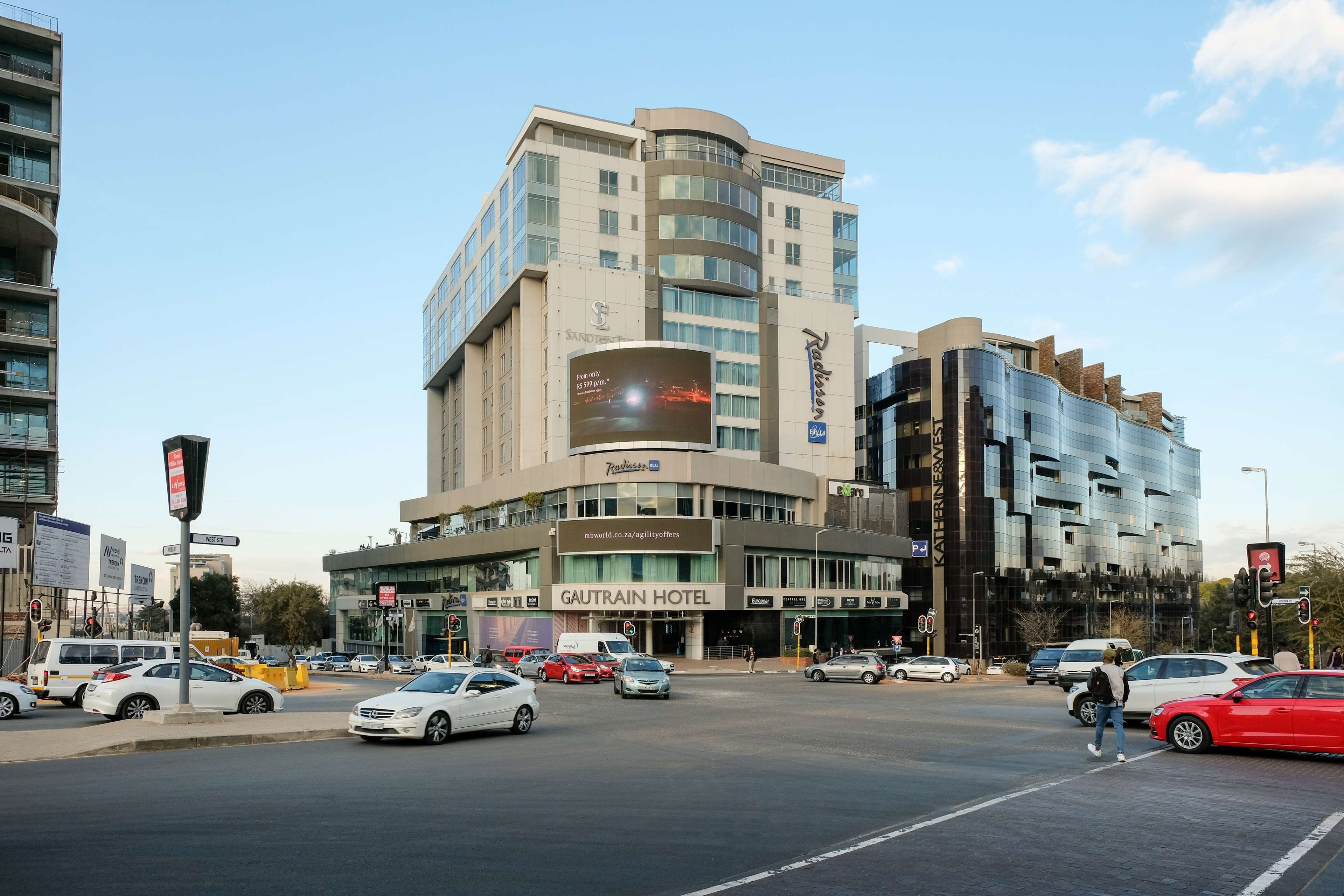 A hotel with a modern design, multiple floors, and a prominent sign.
