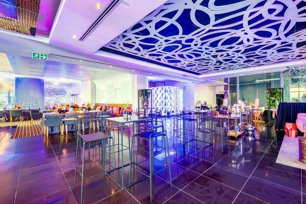 Un restaurante moderno con techos altos, un techo estampado y un suelo pulido.