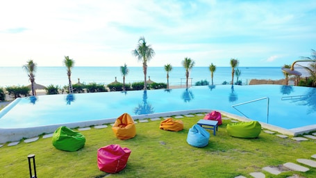 Una piscina al aire libre, sombrillas, sillones reclinables de piscina