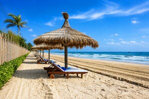 A beach with thatched umbrellas and sun loungers along the shore. - Silver Beach Resort Ke Ga (Tan Thanh)