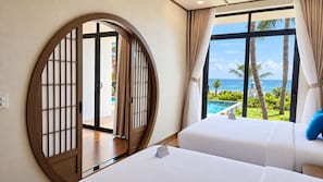 Habitación de hotel con una ventana grande, una cama y vista al océano.