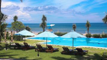 Alberca al aire libre, sombrillas en la alberca y camastros