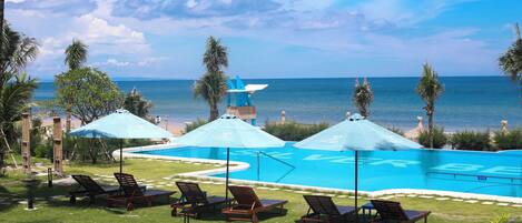 Una piscina al aire libre, sombrillas, sillones reclinables de piscina