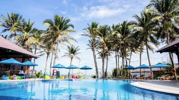 Alberca al aire libre, sombrillas en la alberca y camastros