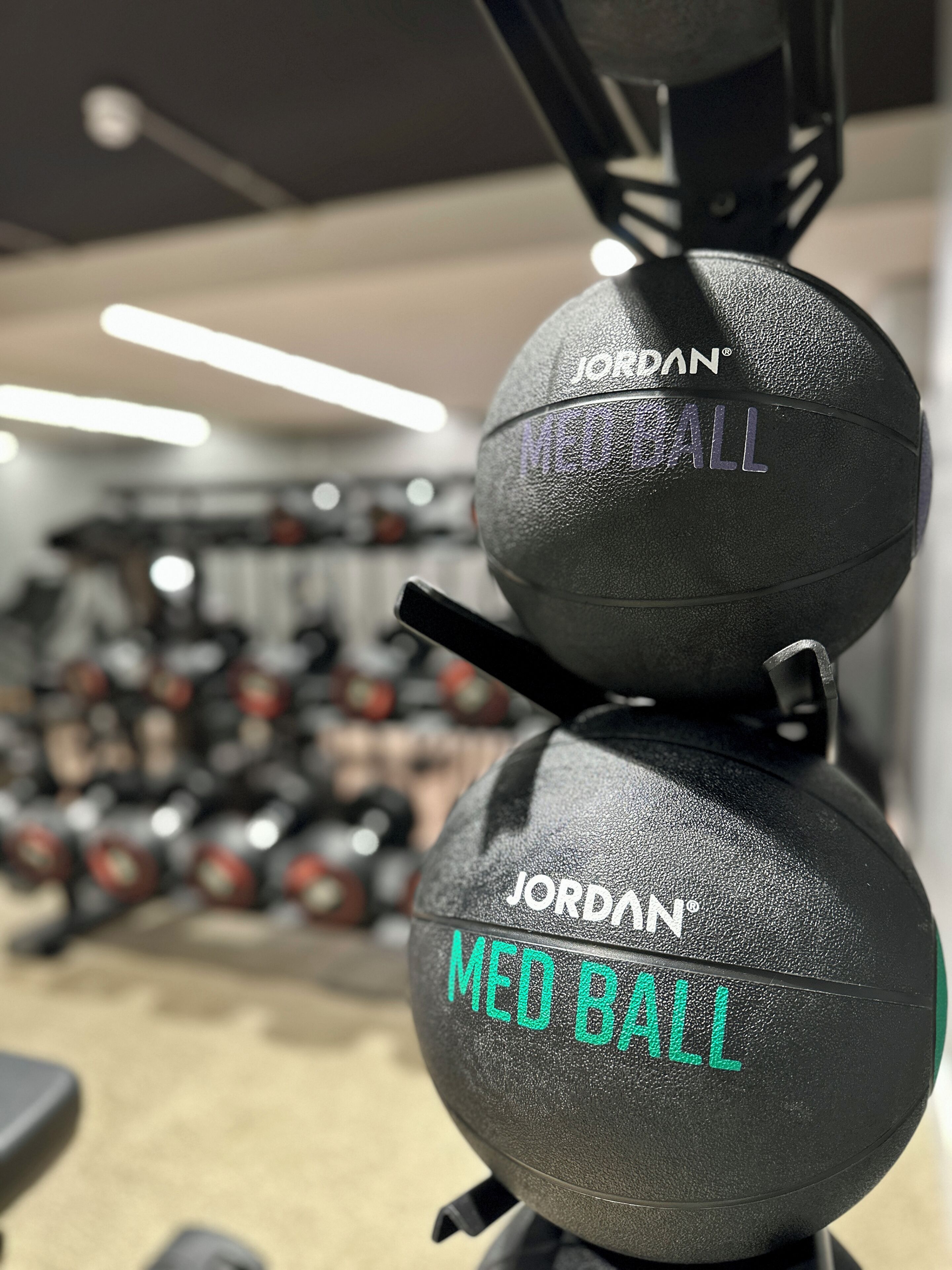 Un gimnasio con equipo de ejercicio, incluyendo un par de balones Med Jordan.