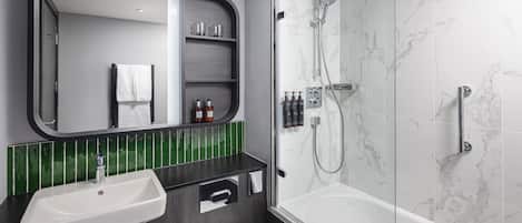 Et moderne badeværelse med et stort spejl, vask, toilet og bruseområde.