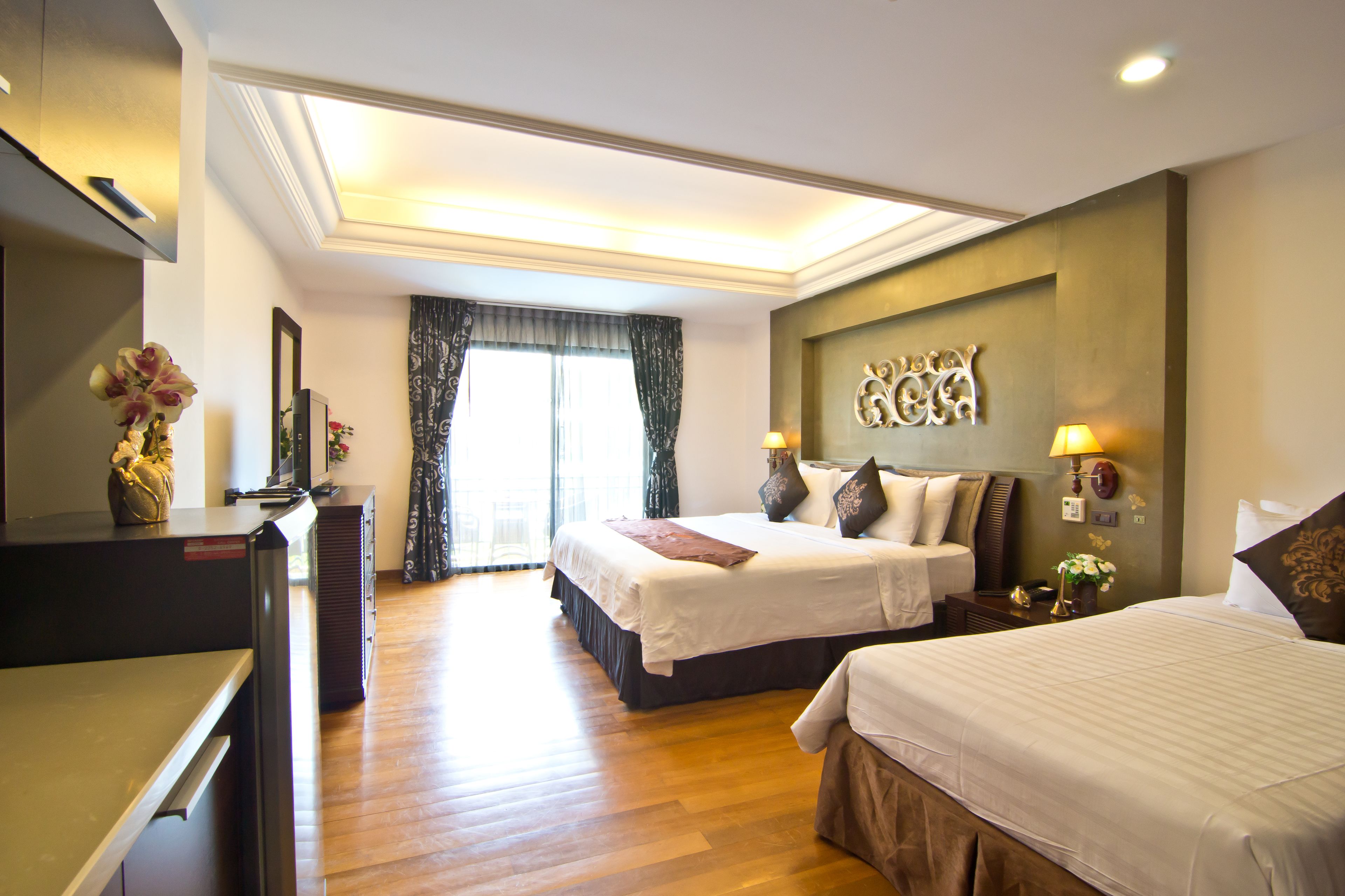 A hotel room with a large bed, a desk, and a mirror.