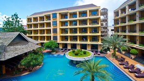 Un hôtel doté de nombreux balcons, d’une piscine centrale et d’espaces de détente en plein air.